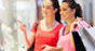 Two women walk along the street, each holding shopping bags from their latest shopping trip